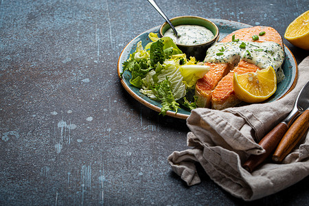 健康食品餐熟烤鲑鱼排配白莳萝酱和绿色沙拉叶