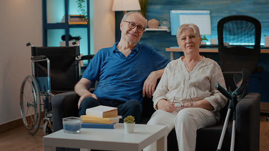 坐在沙发上的残疾退休夫妇的肖像