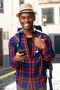背着背包和手机的微笑的非洲裔美国旅行人