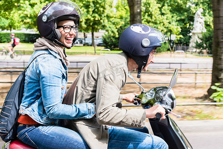 坐在 Vespa 后座上的女人