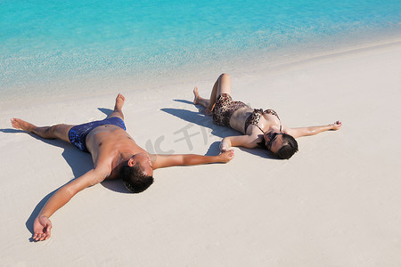 约会夏天摄影照片_快乐的年轻夫妇在海滩上享受夏天