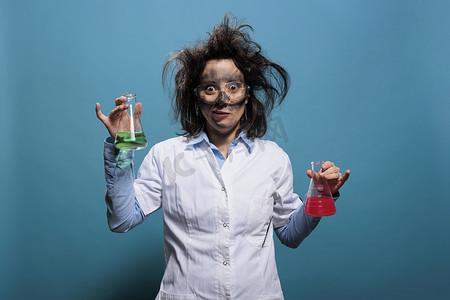 看起来很疯狂的化学家在蓝色背景下拿着装满未知化合物的锥形玻璃罐。