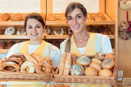 面包店里的两位女售货员拿着一篮面包