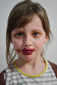 吓人小丑摄影照片_小女孩在玩妈妈的化妆品