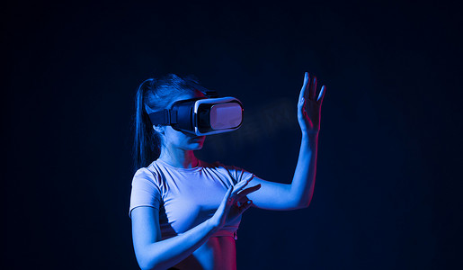 戴着虚拟现实耳机并用手做手势的女建筑师的肖像，她使用 VR 技术进行工业设计、开发、建筑。
