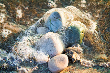 小海龟logo摄影照片_海边的小海石，覆盖着海浪。