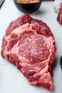 生鲜大理石肉牛排 Ribeye 黑安格斯，白色石头背景，顶视图平躺
