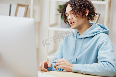 一位身穿蓝色夹克的男子在一台配备电话技术的电脑前的肖像