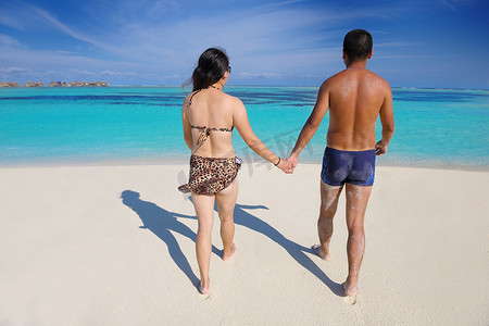 快乐的年轻夫妇在海滩上享受夏天