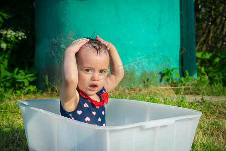 独立浴缸摄影照片_炎炎夏日，一岁半女孩自己洗头