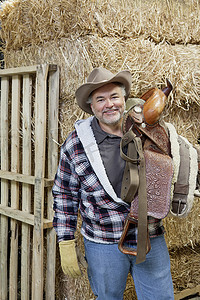 肩上扛着马具的快乐牛仔肖像