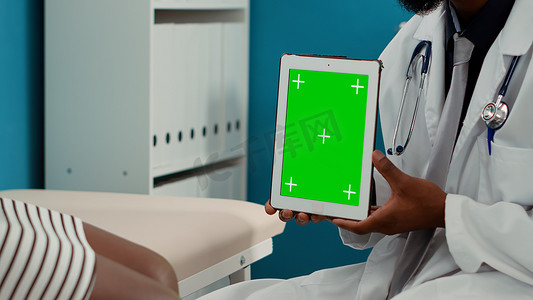 平板电脑绿幕摄影照片_全科医生拿着带绿屏的数字平板电脑