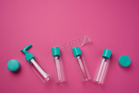 粉色背景、顶视图的各种透明空塑料瓶和化妆品罐