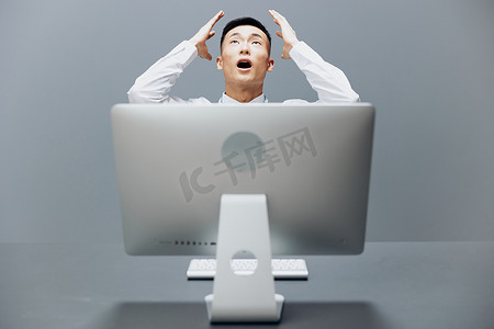 商人坐在电脑前的办公桌前 互联网灰色背景