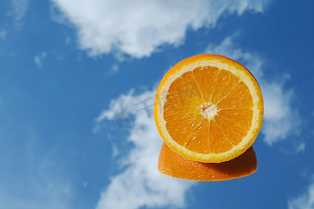 太阳橙色摄影照片_橙色柑橘类水果热带橙色在蓝天和云彩背景。