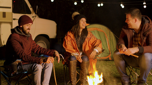 秋天寒冷的夜晚，一群亲密的朋友在篝火旁一起放松