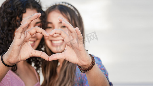 爱之手摄影照片_两个女孩形成心形的特写，两个朋友一起形成心形，爱的手势