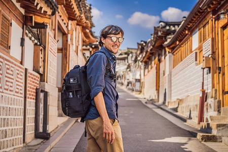 韩屋村摄影照片_北村韩屋村的年轻游客是韩国传统房屋保存完好的著名地点之一。