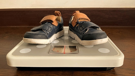 婴儿鞋放在体重秤上的图片。
