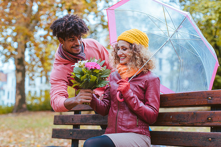 男人在一个毛毛细雨的秋日用一束鲜花给妻子惊喜
