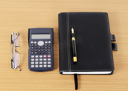 钢笔和信纸摄影照片_钢笔和商业书籍以及计算器和眼镜
