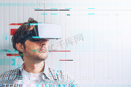 电子错误摄影照片_戴着 VR 护目镜的男人探索虚拟现实电子内容