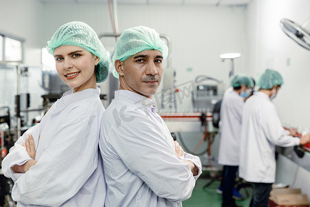 在食品厂工作的肖像团队工人工作人员站着看着镜头开心的微笑。