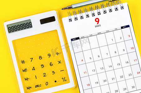 2022 年 9 月台历，黄色背景上带有计算器和笔。