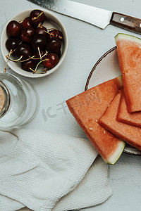 一堆夏天和新鲜水果放在极简主义的白色桌子上，西瓜和樱桃，健康和健康的食物概念，美味，有质感，复制空间