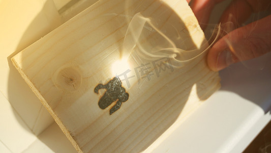 会聚放大镜聚焦的阳光可以燃烧木条。