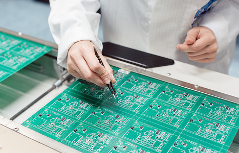 技术人员通过将组件插入电路板来组装电子产品