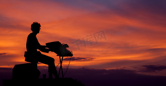 夕阳下弹奏电钢琴的音乐家