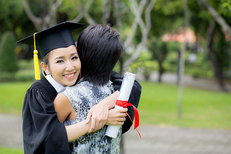 年轻女毕业生在毕业典礼上拥抱她的朋友