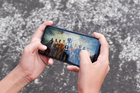 2020鼠年月历摄影照片_在 Android 设备上玩的手机游戏（功能手机或智能手机）。剪短的手青少年玩家男孩在智能手机上玩视频游戏。印度加尔各答南亚太地区 2020 年 2 月
