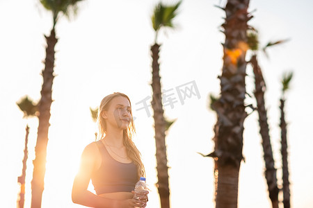 年轻女孩在日落日出时在海滨线上锻炼。