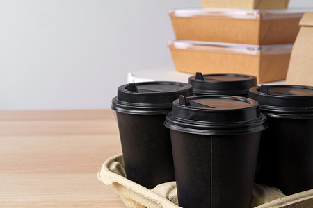 咖啡纸摄影照片_许多不同的外卖食品容器、比萨饼盒、咖啡杯和浅灰色背景中的纸袋