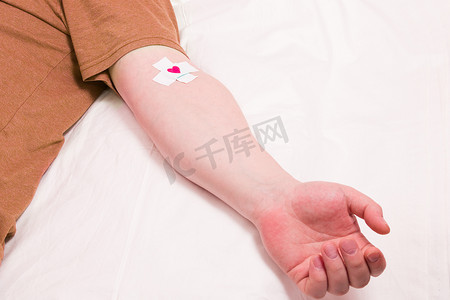 男手贴有十字架，心脏贴在贴片上，献血者概念