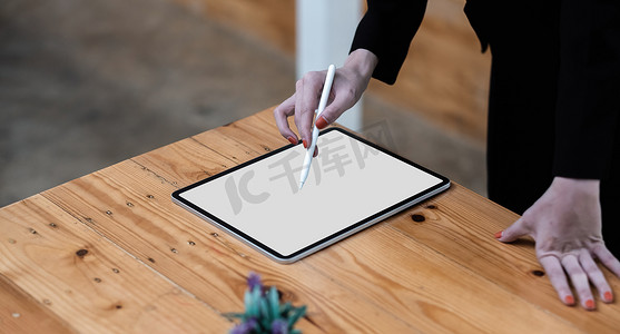 在白色空白屏幕平板电脑上绘图的女商人办公桌特写手