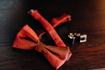 经典新郎配饰：桌上的红色领结和袖扣。