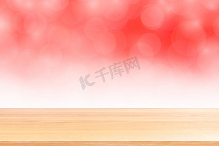 空木桌地板在模糊的散景柔和的红色白色渐变背景上，木板空在红色散景彩色光罩上，彩色散景灯渐变软，用于横幅广告产品