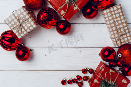 在白色木板上包装小圣诞礼物和红色小玩意