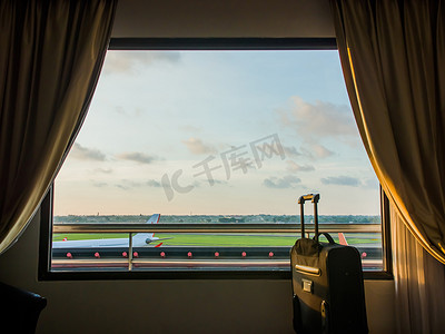 机场附近酒店的窗户以手提箱或行李为背景。