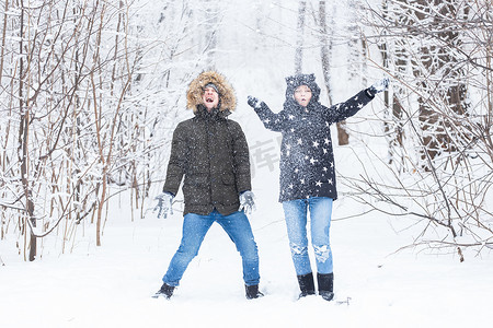 年轻夫妇在冬季公园玩雪