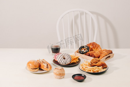 快餐和不健康的饮食概念 — 木桌上汉堡包或芝士汉堡、炸鱿鱼圈、炸薯条、饮料和番茄酱的特写