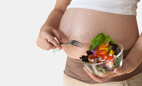 孕妇的肚子和蔬菜沙拉。