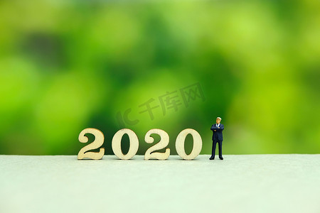 梦幻背景绿色摄影照片_商人用梦幻般的绿色背景问候 2020 年新年快乐