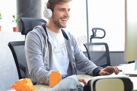 穿着休闲服的微笑年轻人使用电脑、流媒体播放或演练视频。