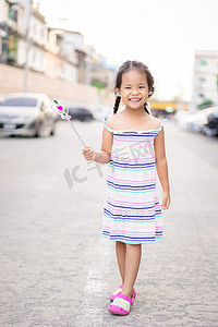穿着裙子的快乐亚洲小女孩站在大街上的肖像