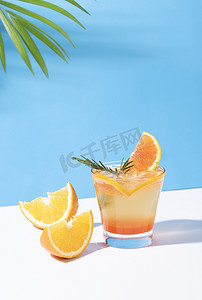 橙色清爽背景摄影照片_橙色潘趣鸡尾酒冷而清爽，颜色背景上有橙色切片。