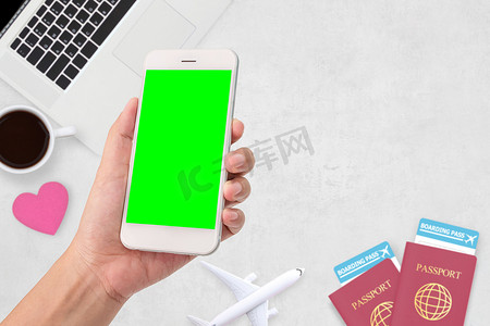 女人手拿着一个现代移动智能手机与空白的绿色屏幕。